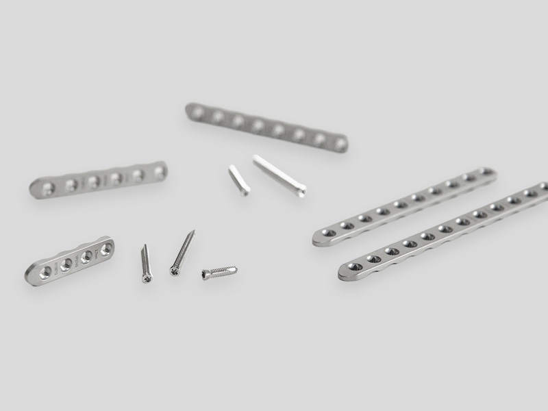 PLS2 orthopedic fixation plates and screws in various sizes, arranged on a light background.